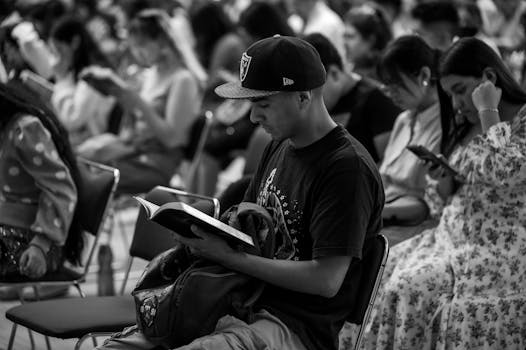Black and white photo of a man reading in a religious gathering in Mexico City.